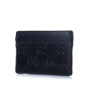 Gucci kaarthouder van zwart leer met monogramreliëf.
